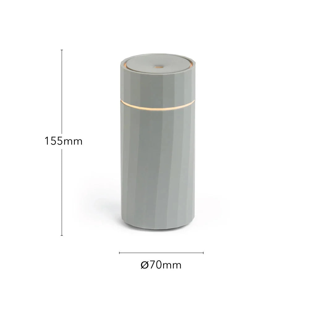 Compact Nomad rechargeable diffuser by Hideaway Home Fragrances placed cord-free on a modern workspace desk