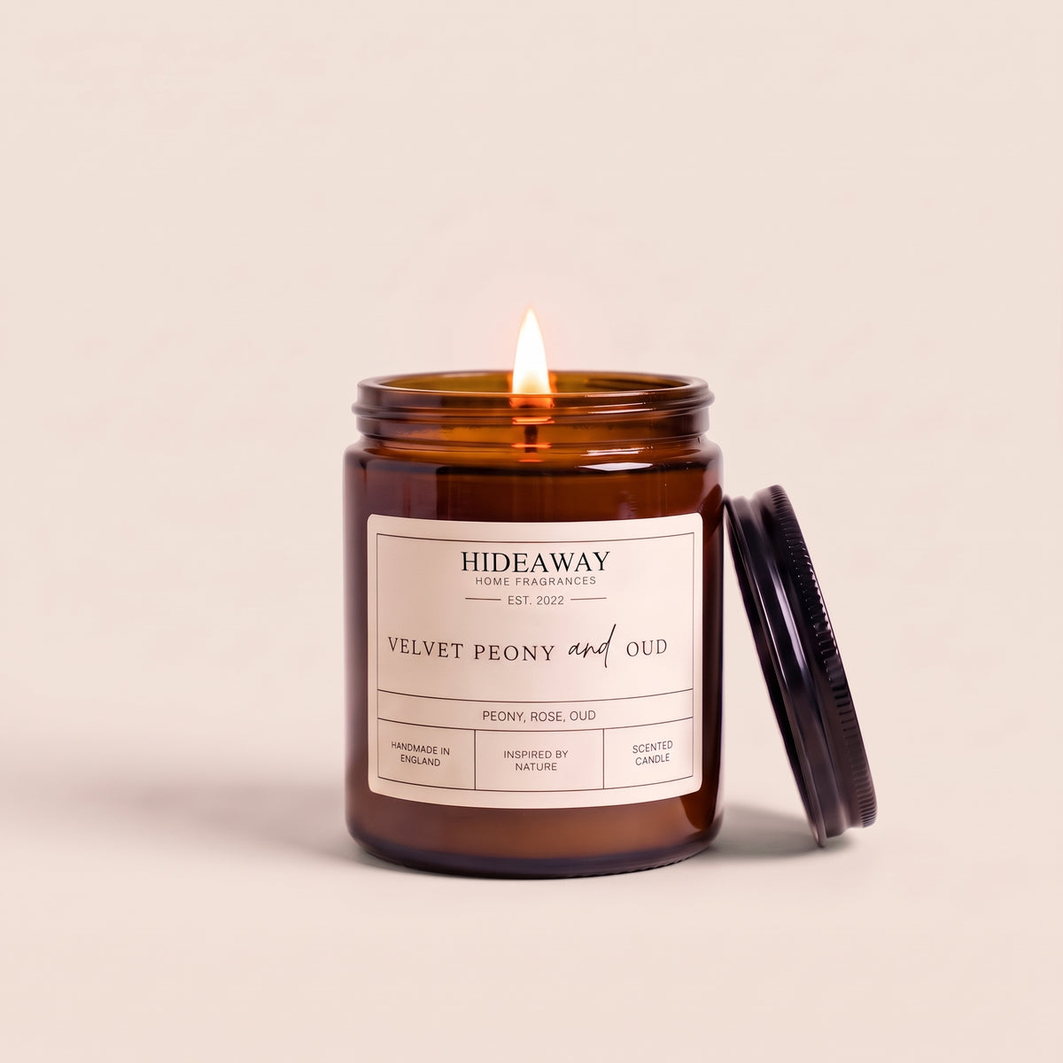 Hand-poured velvet peony and oud amber glass candle featuring notes of lush peony, smoky oud wood, and damask rose, Hideaway Home Fragrances