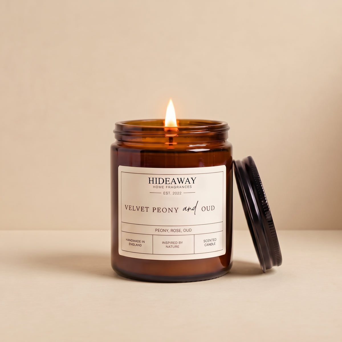 Hand-poured velvet peony and oud amber glass candle featuring notes of lush peony, smoky oud wood, and damask rose, Hideaway Home Fragrances