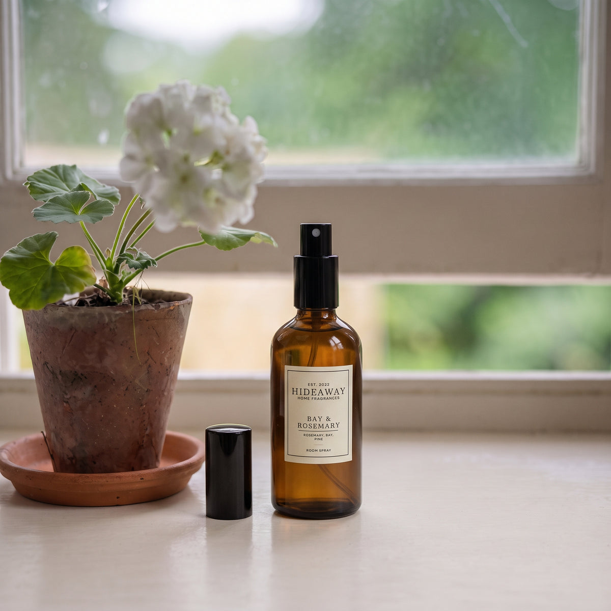 Living room coffee table styled with Hideaway Home Fragrances bay and rosemary room spray alongside dried lavender and pine sprigs.