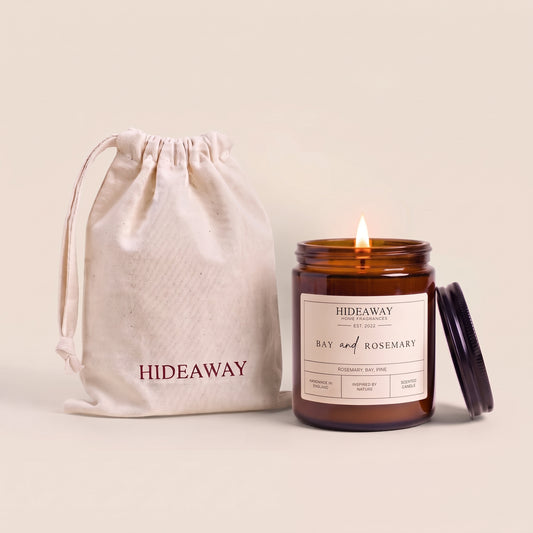 Hand-poured bay and rosemary scented candle in a warm amber glass jar by Hideaway Home Fragrances