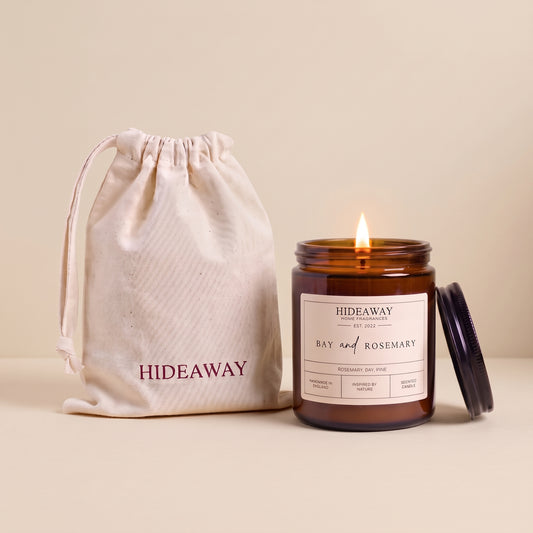 Hand-poured bay and rosemary scented candle in a warm amber glass jar by Hideaway Home Fragrances