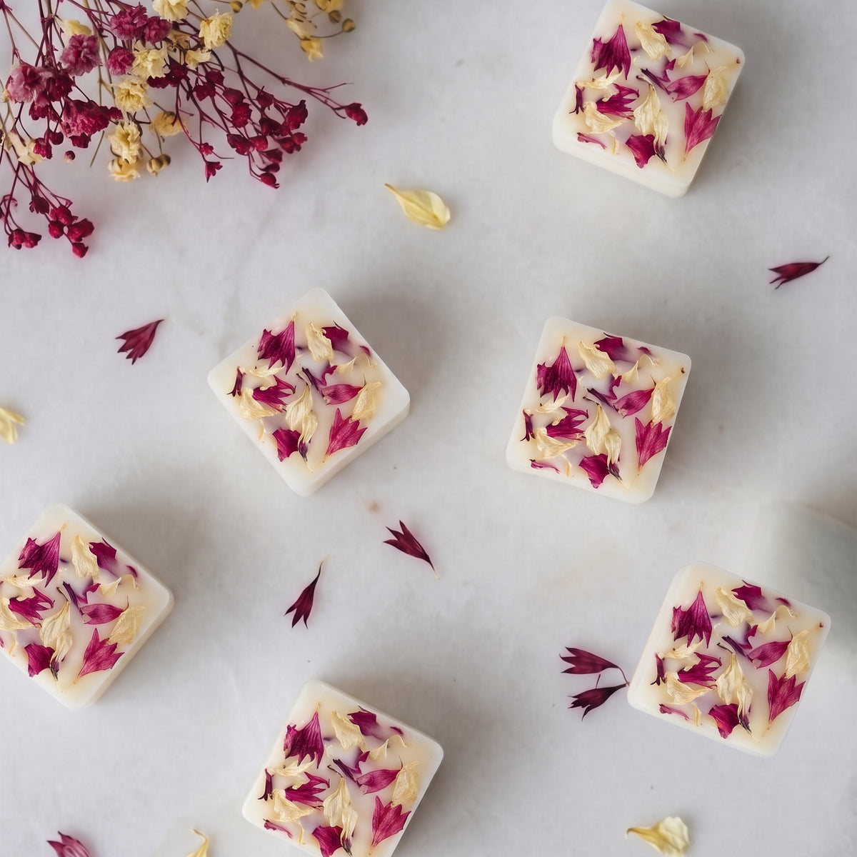 Deep fruity plum and wild rhubarb wax melt cube melting in a ceramic burner dish by Hideaway Home Fragrances releasing sweet blackberry and pear aromas