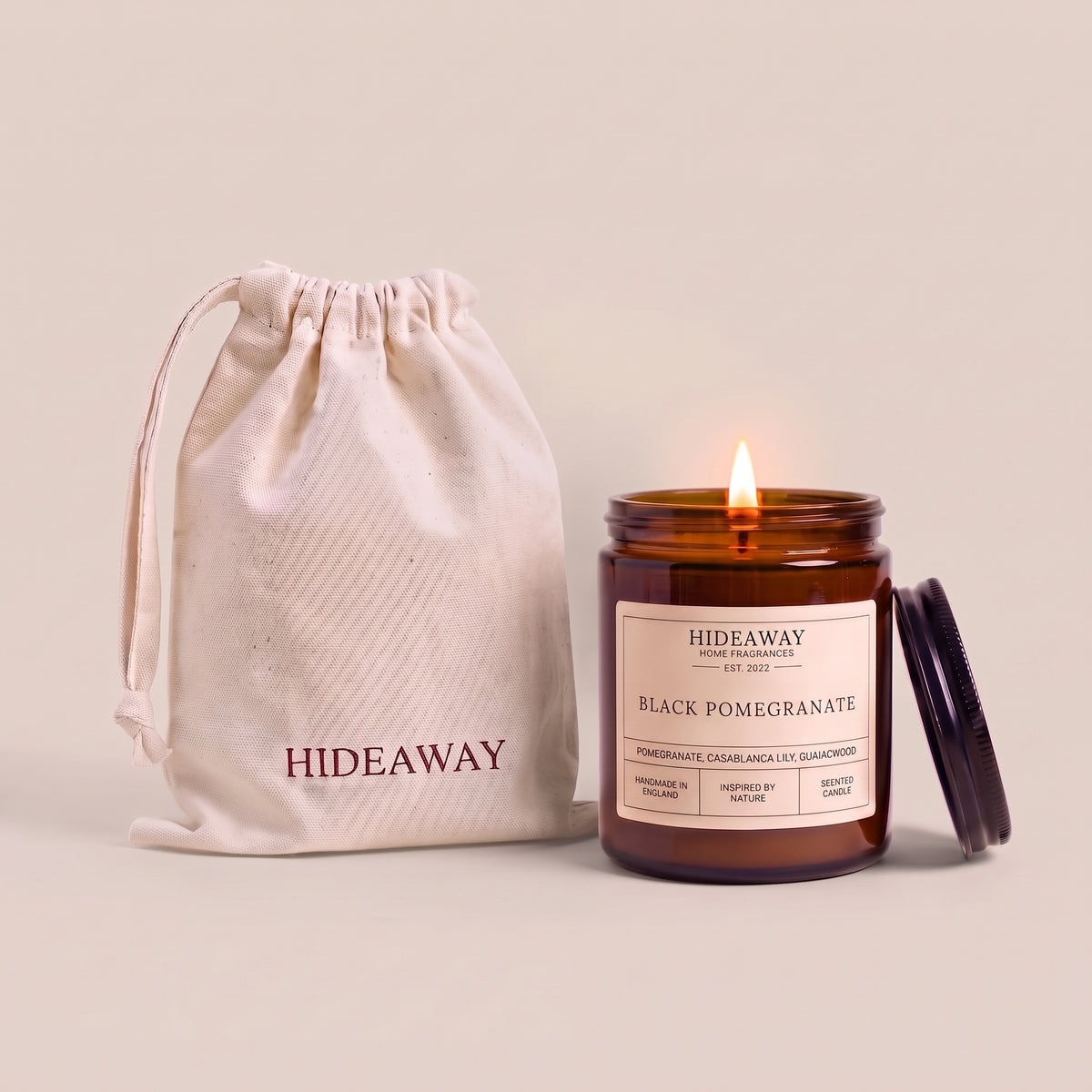 Hand-poured black pomegranate scented candle in a warm amber glass jar by Hideaway Home Fragrances