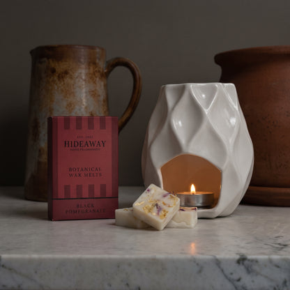 Luxury black pomegranate botanical soy wax melt bar by Hideaway Home Fragrances topped with dark botanical botanicals