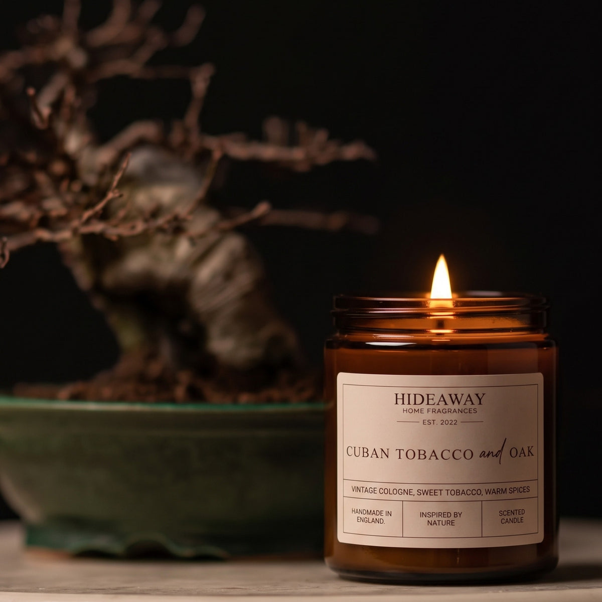 Soy wax Cuban tobacco and oak scented candle in amber glass jar styled on a wooden shelf, Hideaway Home Fragrances