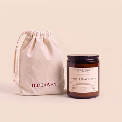 Earthy green tomato vines aromatic candle in an amber glass jar creating a fresh garden mood from Hideaway Home Fragrances