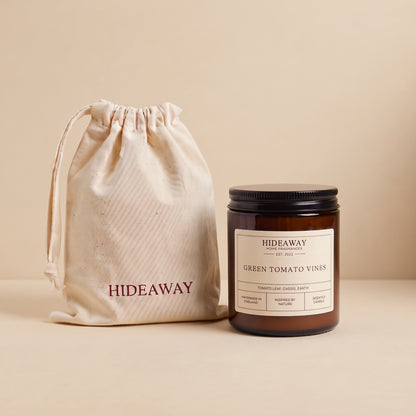 Earthy green tomato vines aromatic candle in an amber glass jar creating a fresh garden mood from Hideaway Home Fragrances
