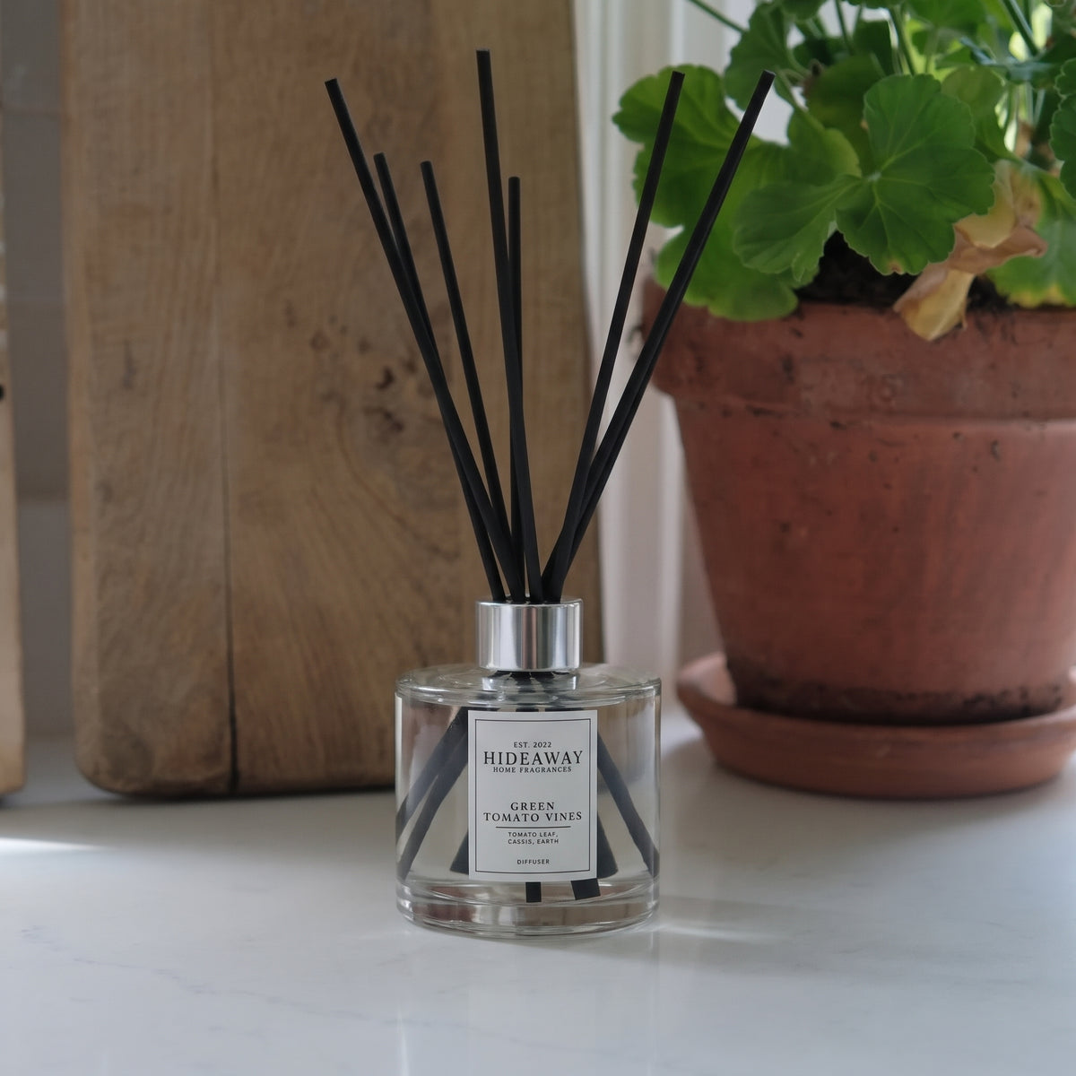 Hideaway Home Fragrances green tomato vines reed diffuser bottle with natural reeds on a shelf