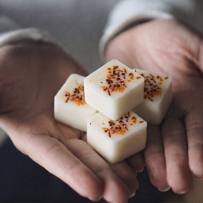 Close up of Hideaway Home Fragrances green tomato vines botanical wax melts highlighting embedded herbs, orange blossom, and orchid notes