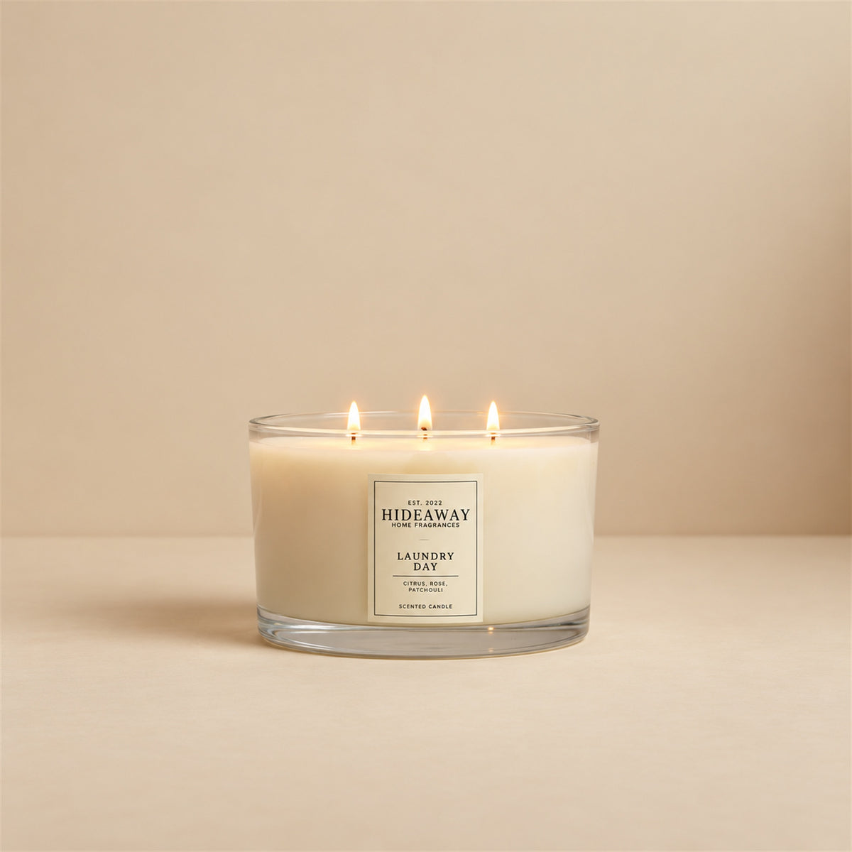 Lit Laundry Day 3 wick soy candle by Hideaway Home Fragrances burning on a clean table for a fresh home atmosphere