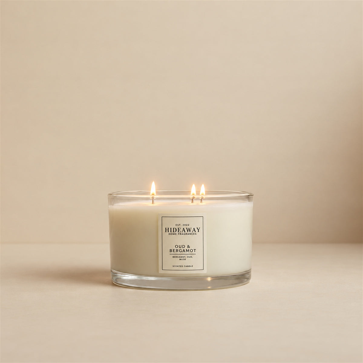 Lit Oud and Bergamot 3 wick soy candle by Hideaway Home Fragrances burning in a modern living room for a warm ambient atmosphere