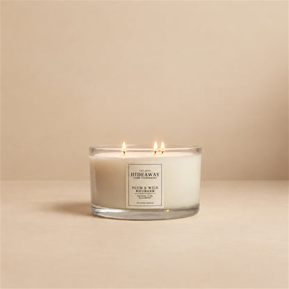 Lit Plum and Wild Rhubarb 3 wick soy candle by Hideaway Home Fragrances burning on a dining table for a vibrant fruity atmosphere