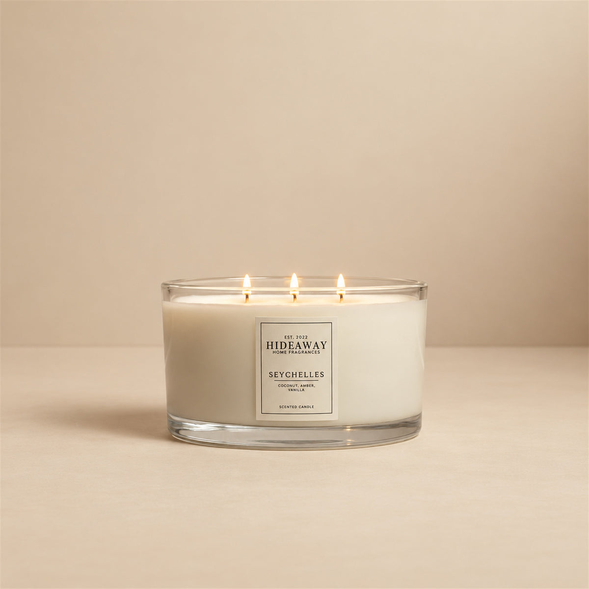 Lit Seychelles 3 wick soy candle by Hideaway Home Fragrances burning on a bathroom shelf for a relaxed spa atmosphere