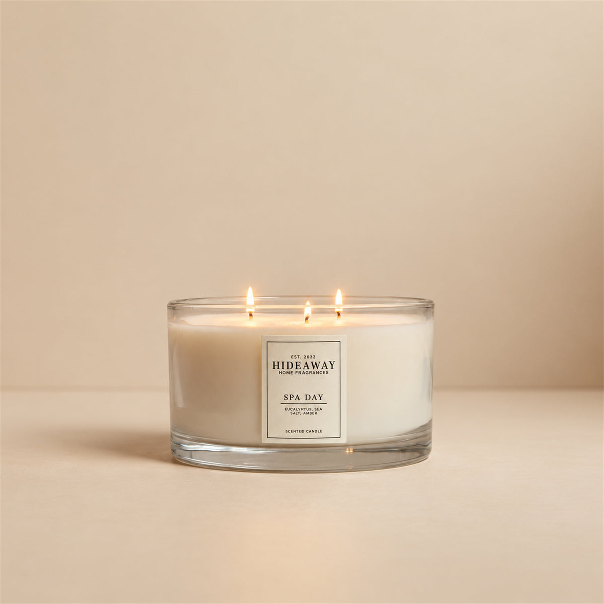 Lit Spa Day 3 wick soy candle by Hideaway Home Fragrances burning next to a bathtub for a relaxing home spa experience