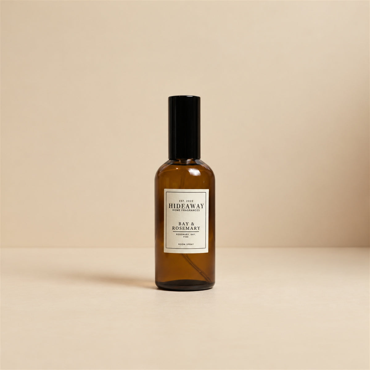 Person misting the herbal Hideaway Home Fragrances bay and rosemary room spray to freshen a bedroom space.