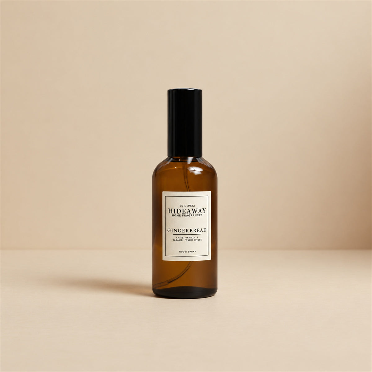 Hideaway Home Fragrances gingerbread room spray styled on a kitchen counter beside warm cinnamon sticks and baked holiday cookies.