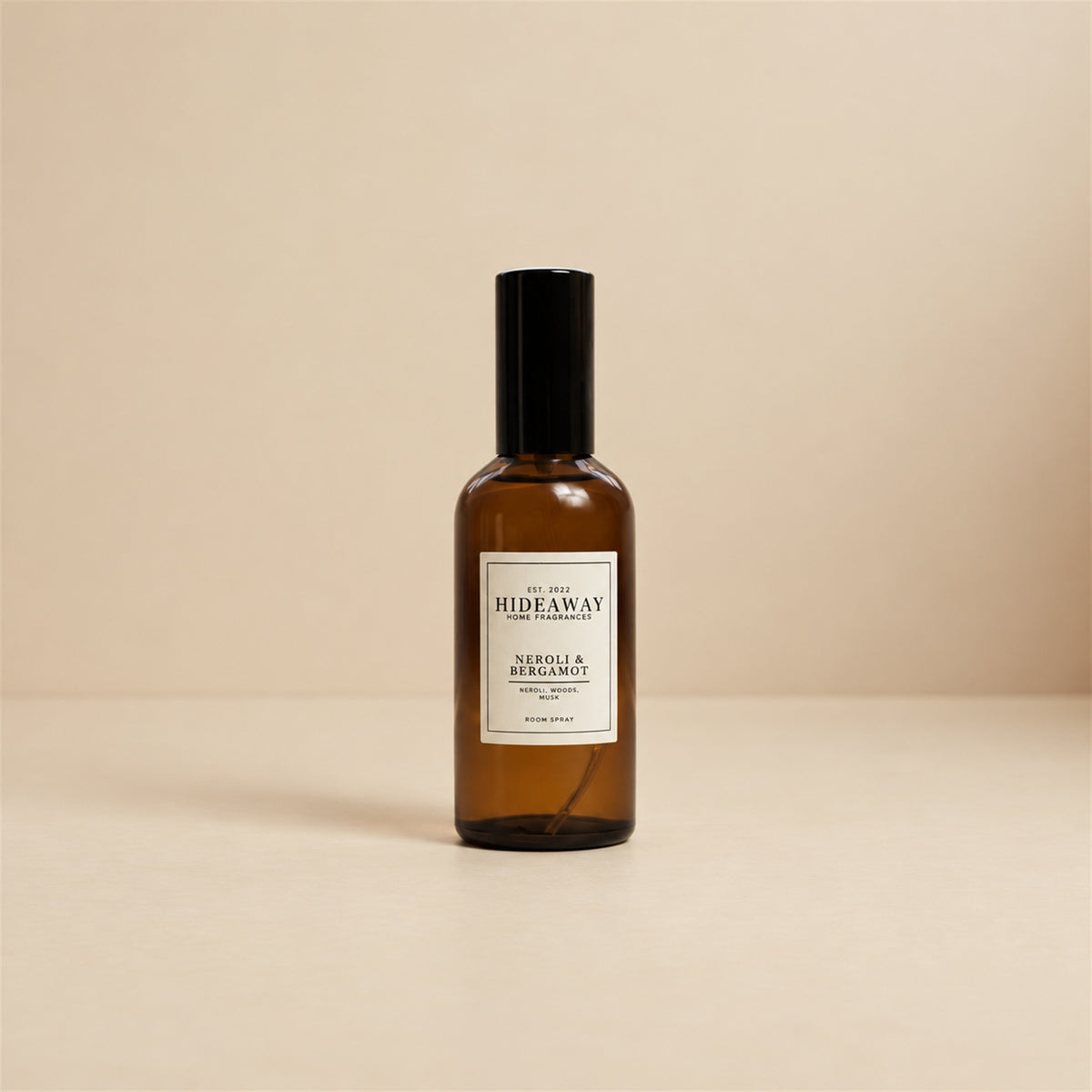 Hideaway Home Fragrances neroli and bergamot room spray arranged on an oak dressing table beside fresh orange blossom sprigs.