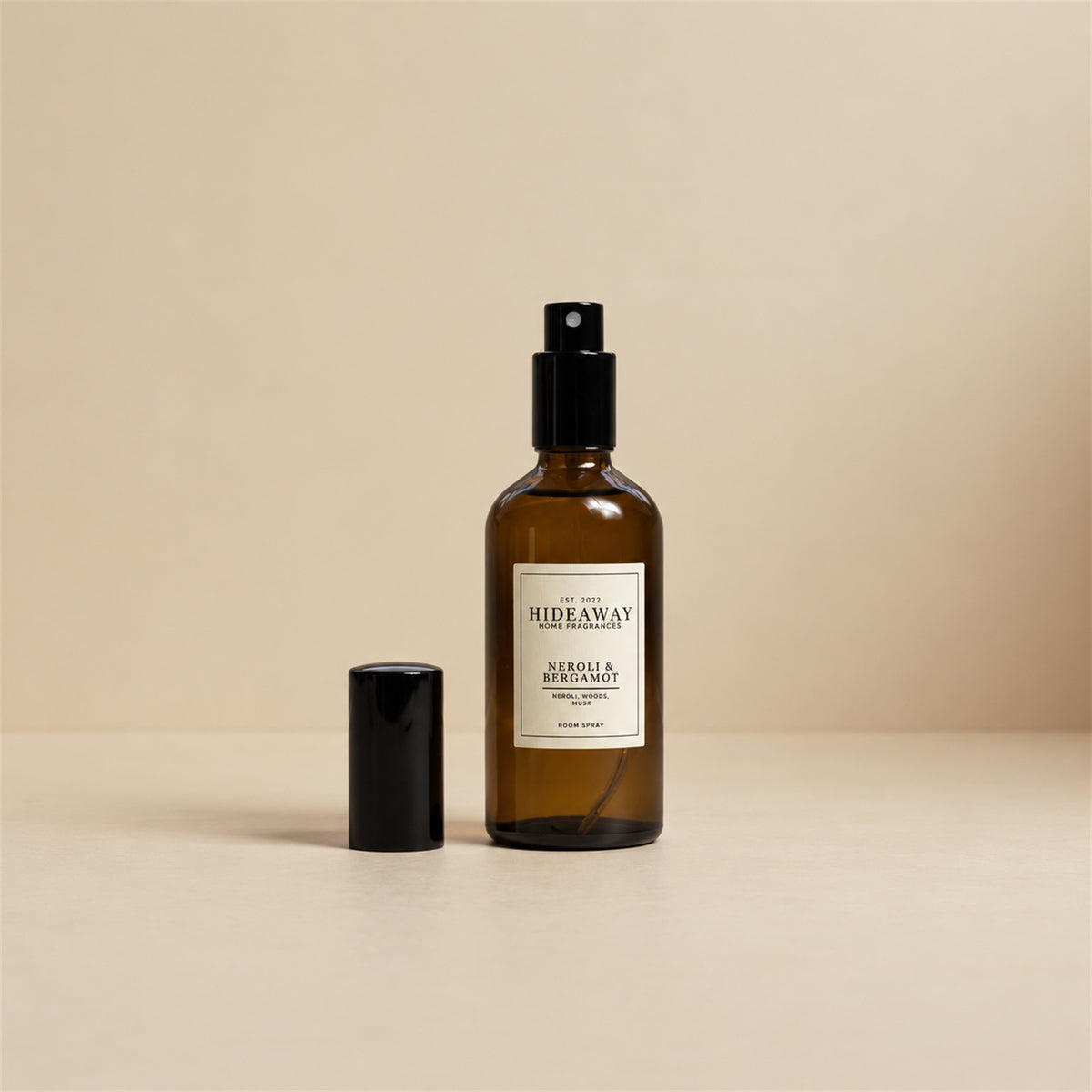 Fine mist spraying from the Hideaway Home Fragrances neroli and bergamot room spray bottle to disperse warm vanilla, cedarwood, and sheer musk notes.