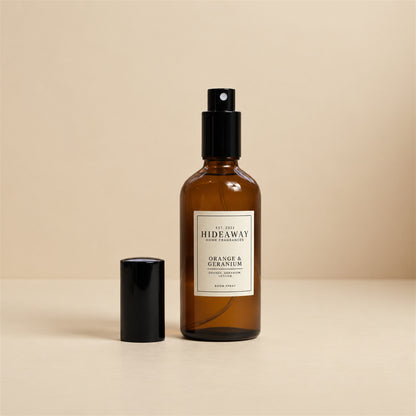 Hand spraying Hideaway Home Fragrances orange and geranium room spray to release uplifting sweet orange and floral geranium notes into the room.