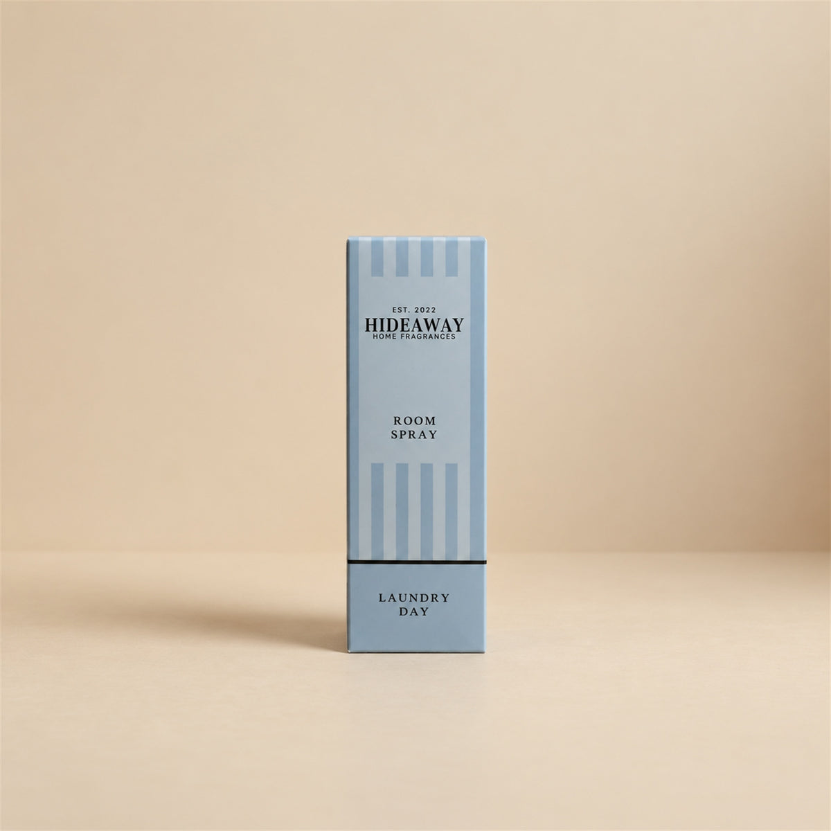 Boxed gift packaging and bottle for Hideaway Home Fragrances laundry day room spray highlighting fresh fruit and green floral notes.