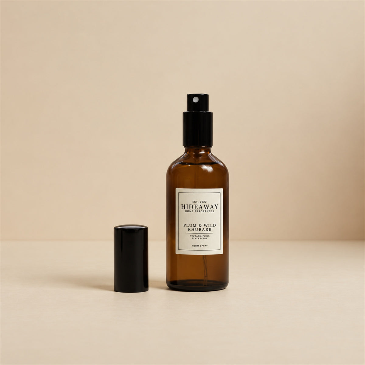 Fine mist spraying from the Hideaway Home Fragrances plum and wild rhubarb room spray bottle to disperse sweet pear and rich berry notes into the room.