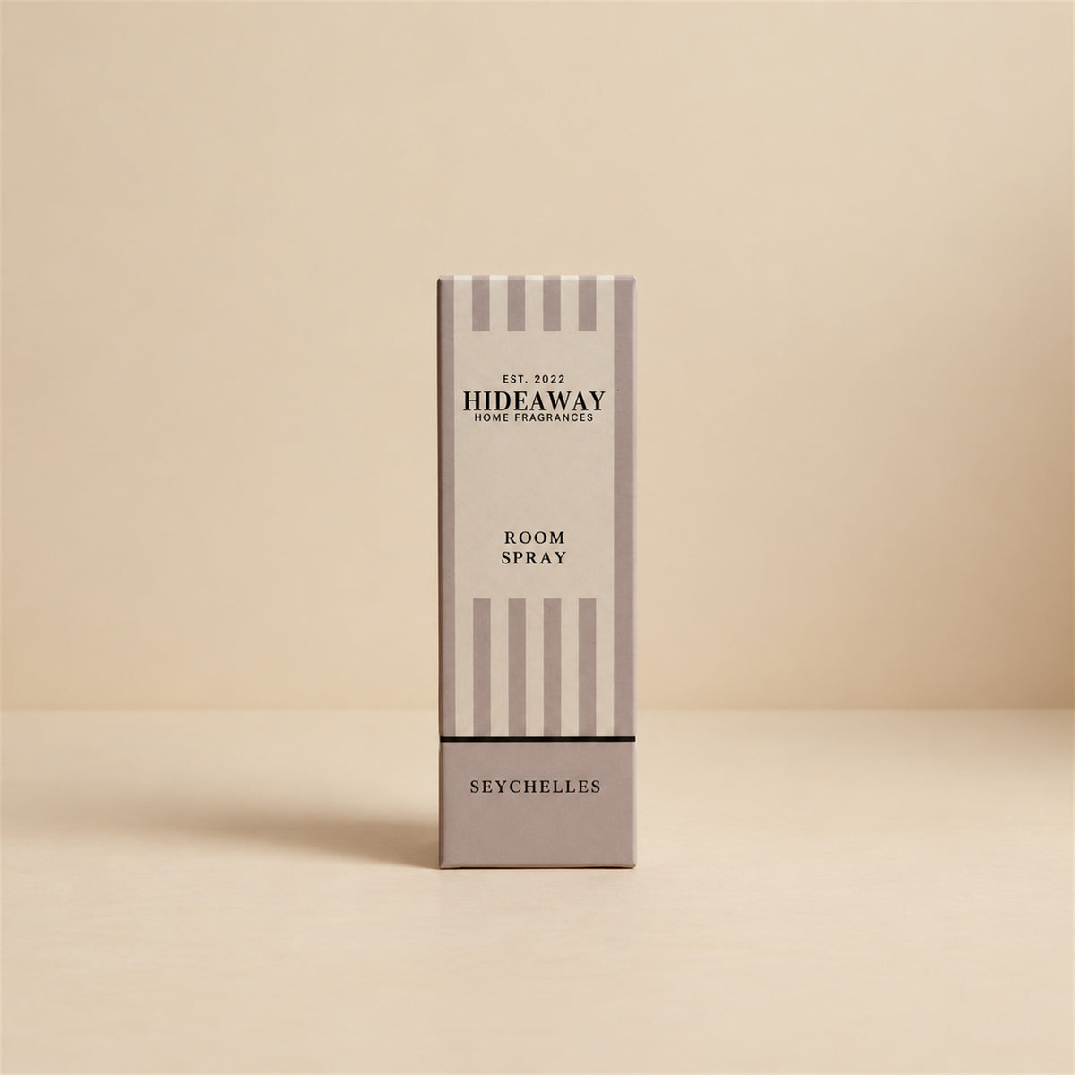Packaged Hideaway Home Fragrances seychelles room spray bottle standing next to its luxury gift box showcasing warm vanilla and amber home fragrance notes.