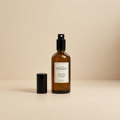 Fine mist spraying from the Hideaway Home Fragrances spa day room spray bottle to diffuse fresh sea salt, herbal thyme, and soothing floral notes.