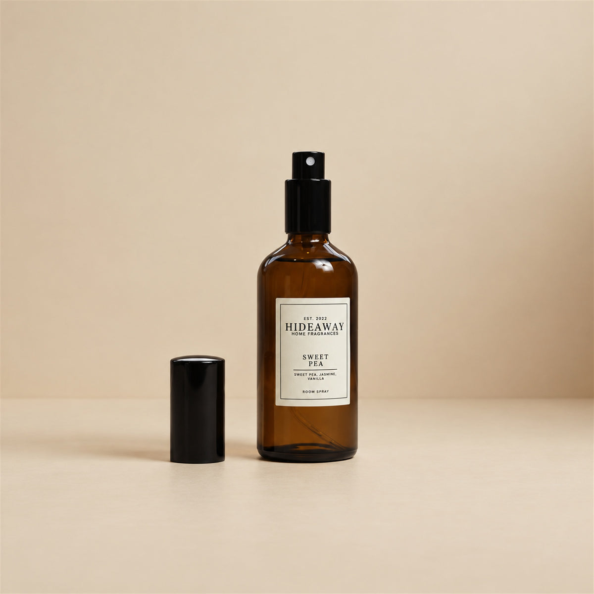 Fine mist spraying from the Hideaway Home Fragrances sweet pea room spray bottle to diffuse soft rose, jasmine, and creamy vanilla notes into the room.
