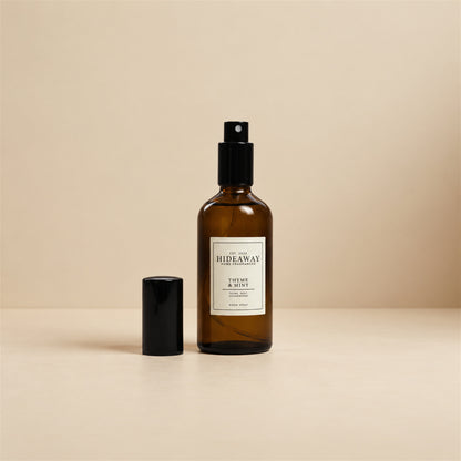 Fine mist released from the Hideaway Home Fragrances thyme and mint room spray bottle to disperse energising bergamot, tea tree, and marjoram aromas.