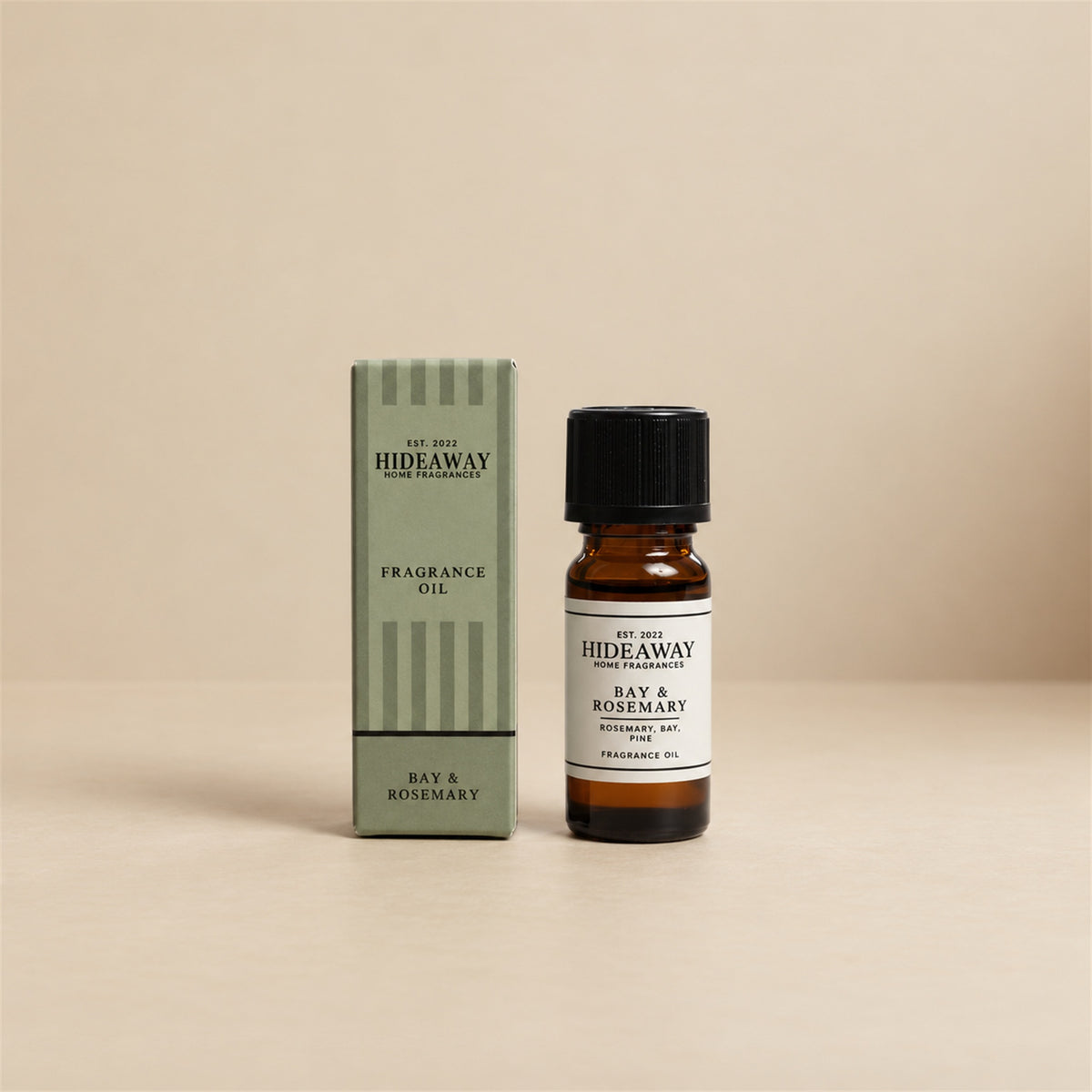 Hideaway Home Fragrances bay and rosemary fragrance oil bottle standing against a seamless neutral studio background.