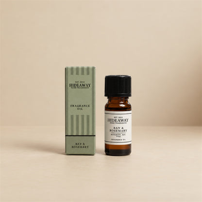 Hideaway Home Fragrances bay and rosemary fragrance oil bottle standing against a seamless neutral studio background.