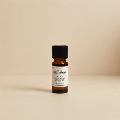 Drops of Hideaway Home Fragrances bay and rosemary fragrance oil added to an electronic diffuser alongside fresh sprigs of rosemary and lavender.