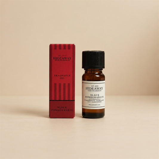 Hideaway Home Fragrances black pomegranate fragrance oil bottle standing against a seamless neutral studio background.