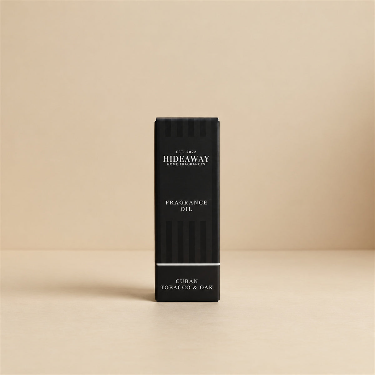 Packaged Hideaway Home Fragrances cuban tobacco and oak fragrance oil bottle beside its luxury retail box highlighting rich clove, tobacco, and musk base notes.