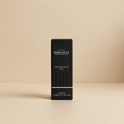 Packaged Hideaway Home Fragrances cuban tobacco and oak fragrance oil bottle beside its luxury retail box highlighting rich clove, tobacco, and musk base notes.