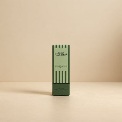 Packaged Hideaway Home Fragrances green tomato vines fragrance oil bottle shown beside its luxury gift box highlighting tagette, rosy floral, and musk notes.