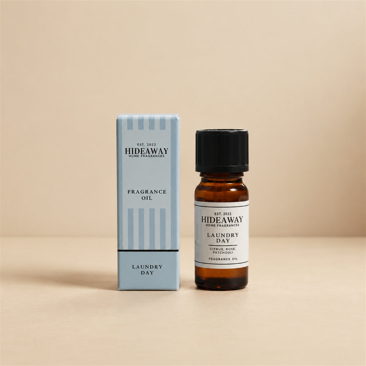 Hideaway Home Fragrances laundry day fragrance oil bottle standing against a seamless neutral studio backdrop.