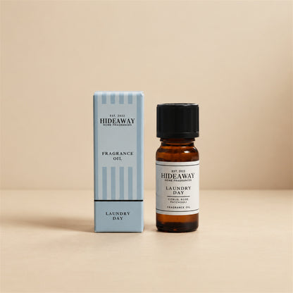 Hideaway Home Fragrances laundry day fragrance oil bottle standing against a seamless neutral studio backdrop.