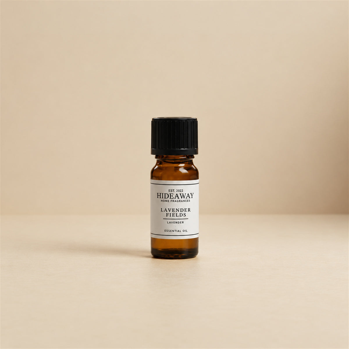 Glass dropper dispensing Hideaway Home Fragrances lavender fields fragrance oil into an aroma diffuser beside dried lavender sprigs for sleep relaxation.