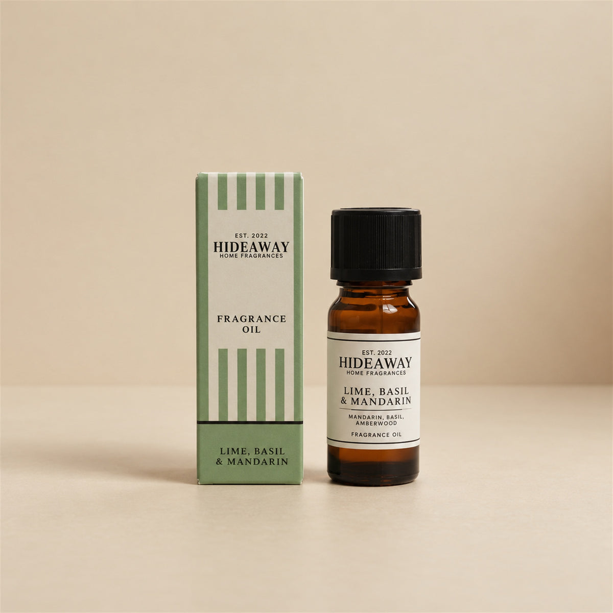 Hideaway Home Fragrances lime basil and mandarin fragrance oil bottle standing against a seamless neutral studio backdrop.