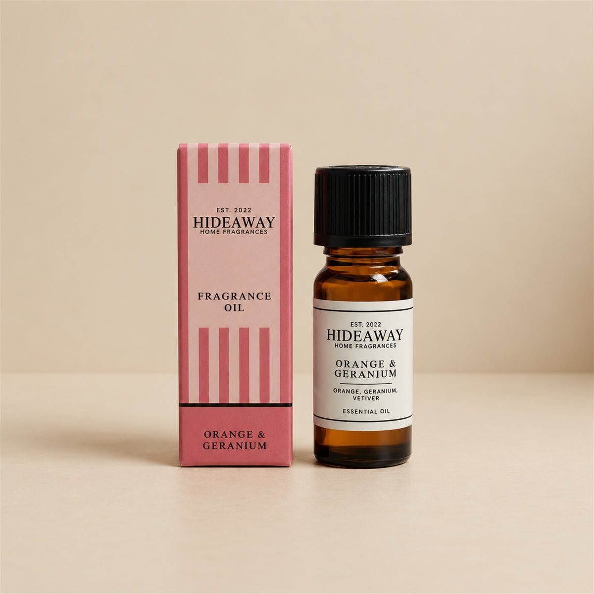Hideaway Home Fragrances orange and geranium fragrance oil bottle standing against a seamless neutral studio backdrop.
