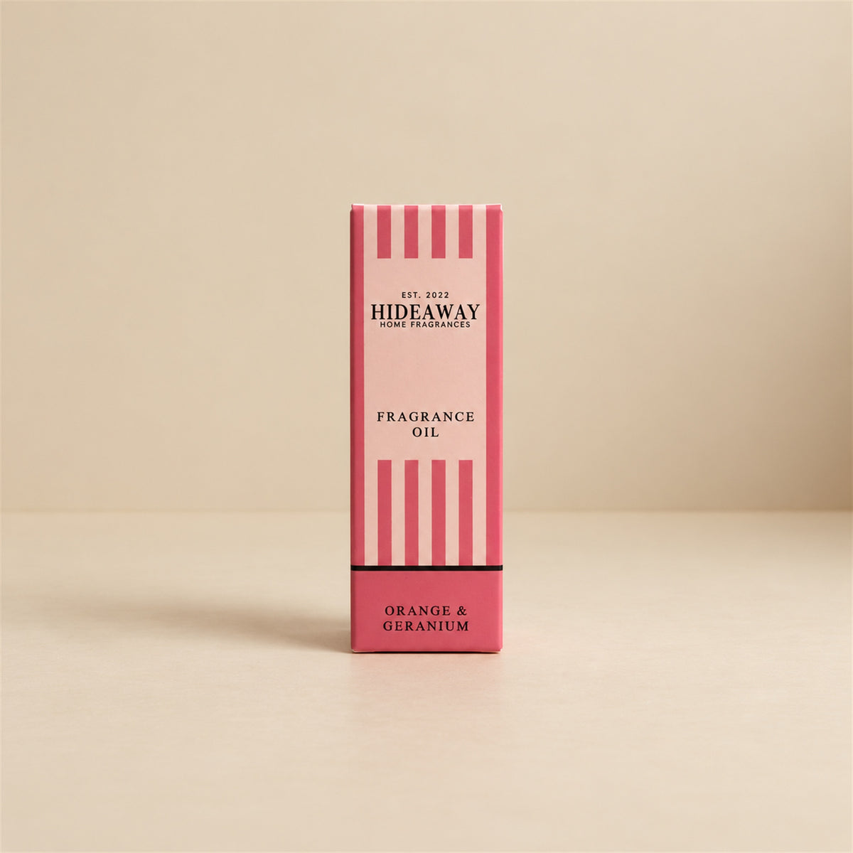 Packaged Hideaway Home Fragrances orange and geranium fragrance oil bottle standing beside its luxury retail box highlighting uplifting citrus and grounded woody notes.