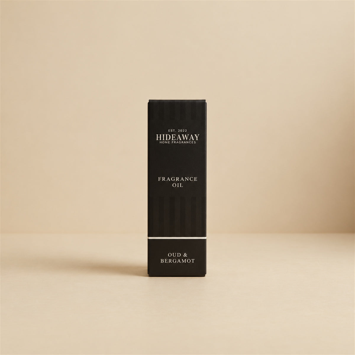 Packaged Hideaway Home Fragrances oud and bergamot fragrance oil bottle standing beside its luxury retail box highlighting citrus, precious woods, and musk notes.