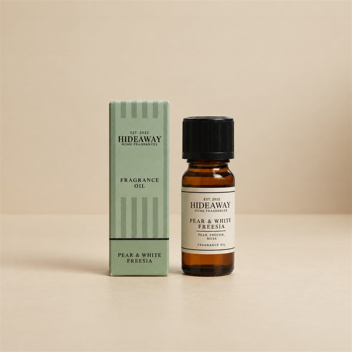Hideaway Home Fragrances pear and white freesia fragrance oil bottle standing against a seamless neutral studio background.