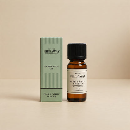 Hideaway Home Fragrances pear and white freesia fragrance oil bottle standing against a seamless neutral studio background.
