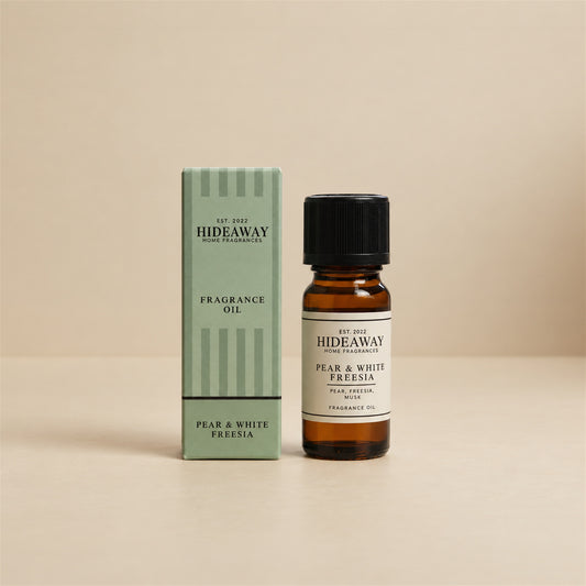 Hideaway Home Fragrances pear and white freesia fragrance oil bottle standing against a seamless neutral studio background.