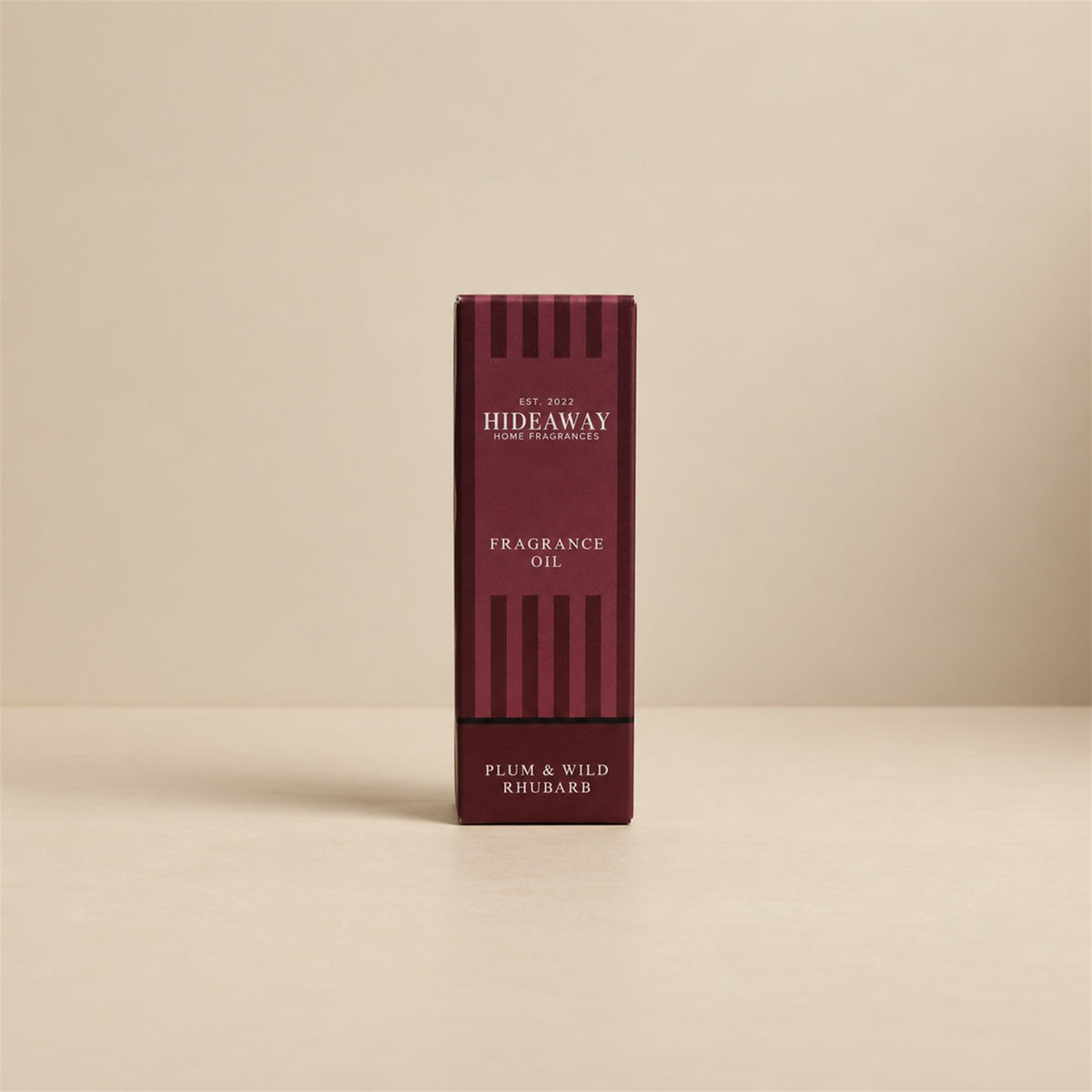 Packaged Hideaway Home Fragrances plum and wild rhubarb fragrance oil bottle standing beside its luxury retail box highlighting crisp rhubarb and sweet pear notes.