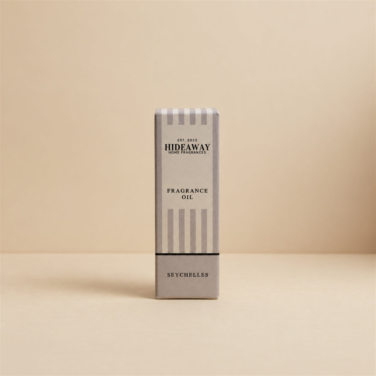 Packaged Hideaway Home Fragrances seychelles fragrance oil bottle standing beside its luxury retail box highlighting warm butter, jasmine, and sweet vanilla notes.