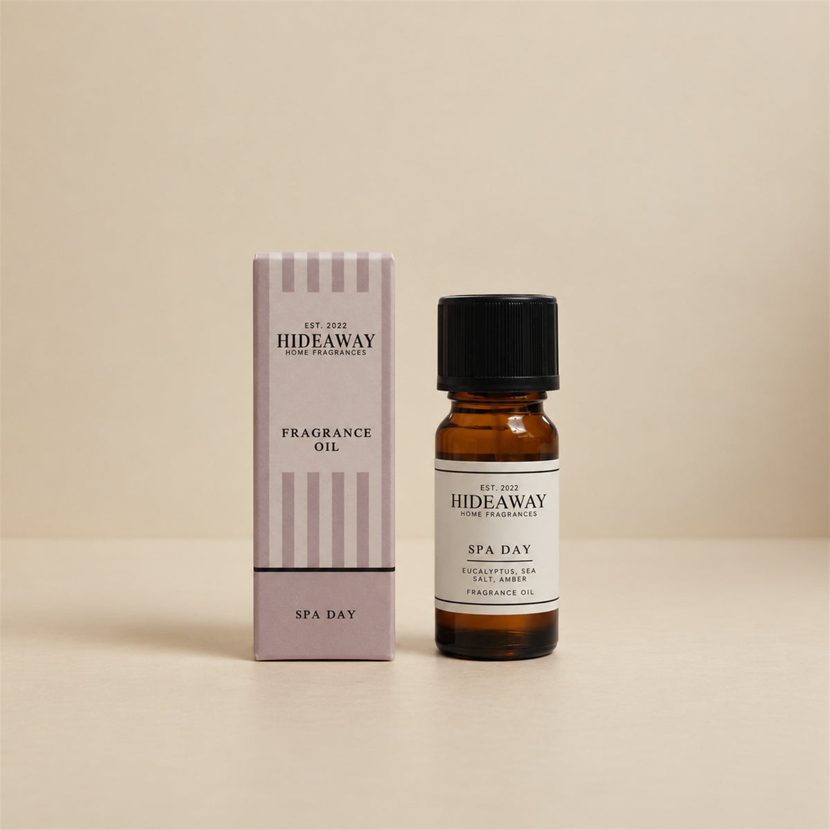 Hideaway Home Fragrances spa day fragrance oil bottle standing against a seamless neutral studio backdrop.
